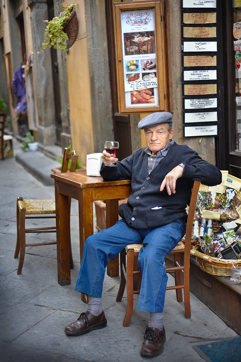 portrait photo of an older gentleman drinking wine