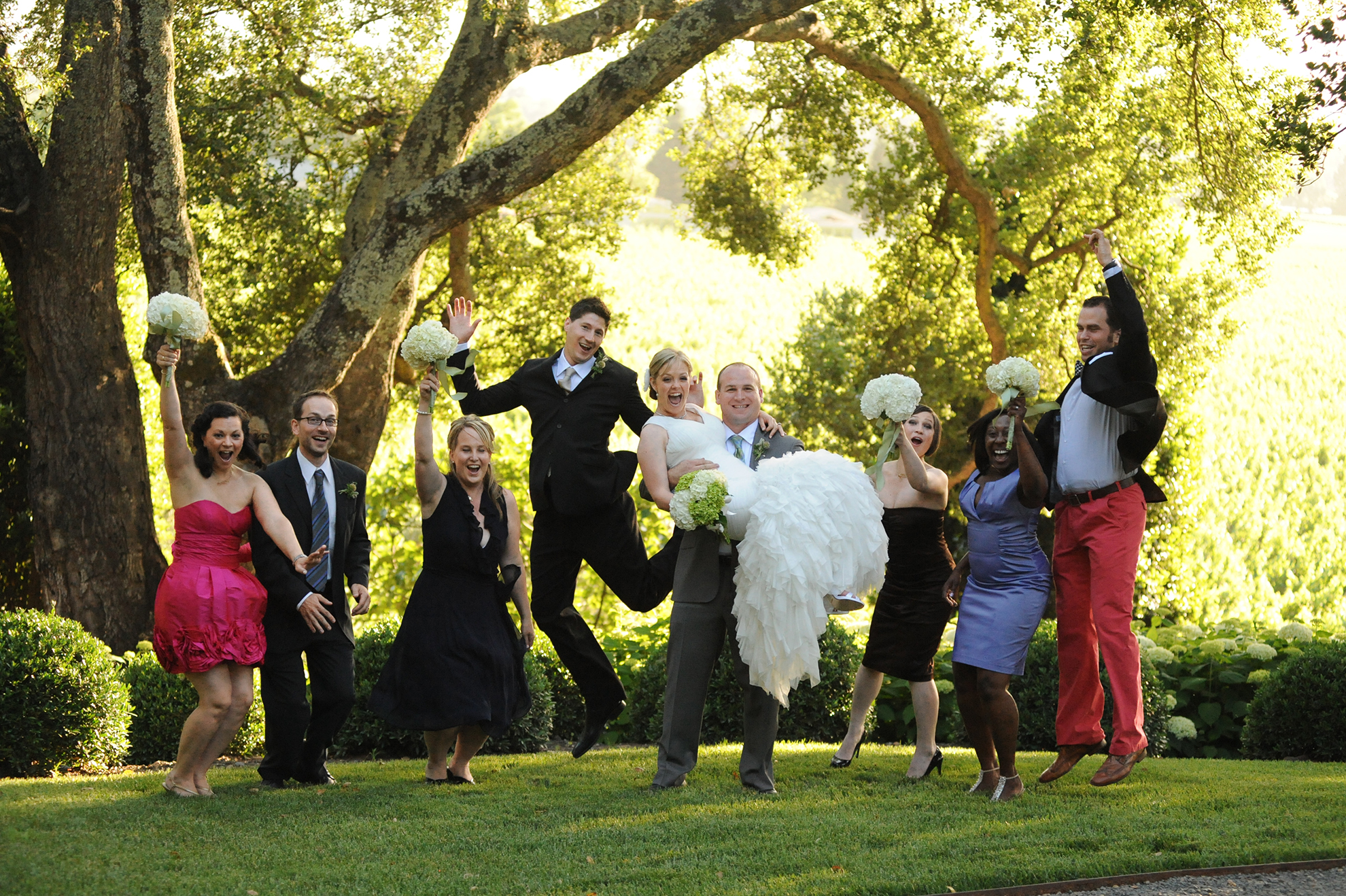 Bride, groom, and bridal party jumping