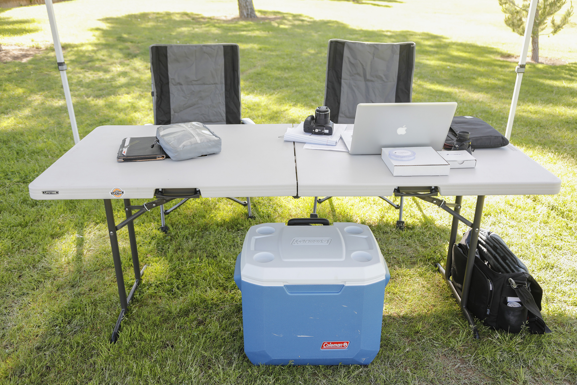 table with chairs, laptop, cooler