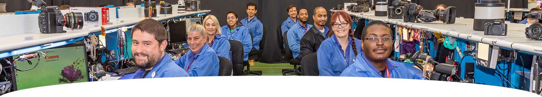 Image of Canon Virginia employees sitting at computer desk stations and smiling