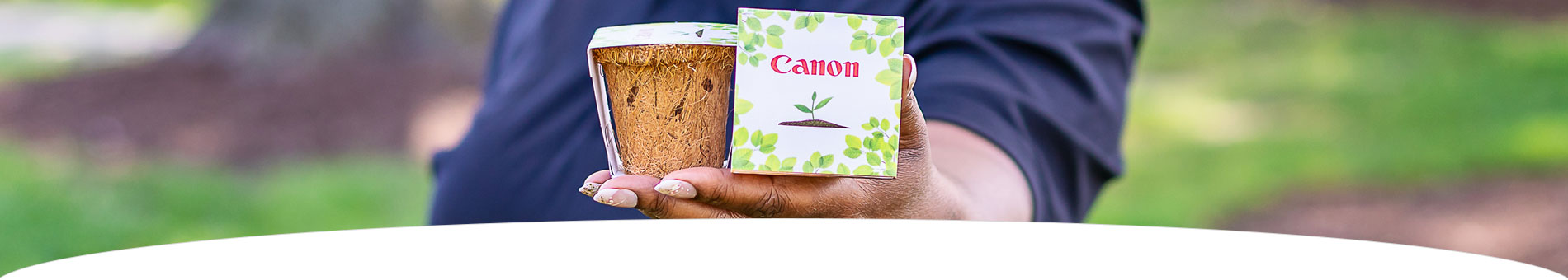 Imaghe of hands holding a note with the Canon logo and images of leaves
