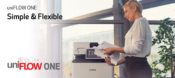 Woman going through a document while standing next to a Canon printer