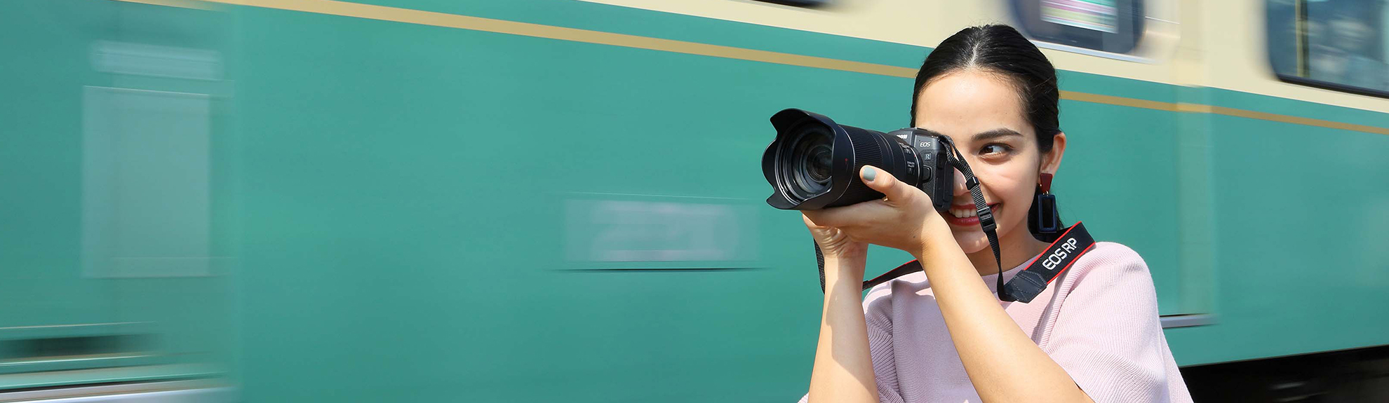 Woman using camera, standing next to train
